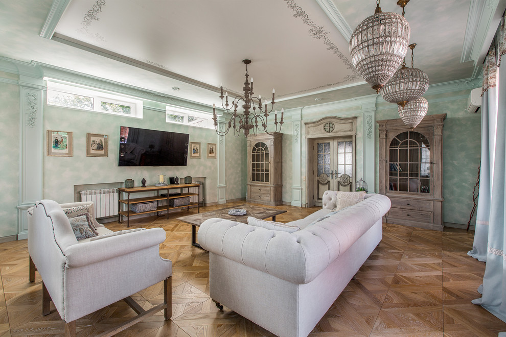 Imagen de salón para visitas cerrado romántico con paredes verdes, suelo de madera en tonos medios y televisor colgado en la pared