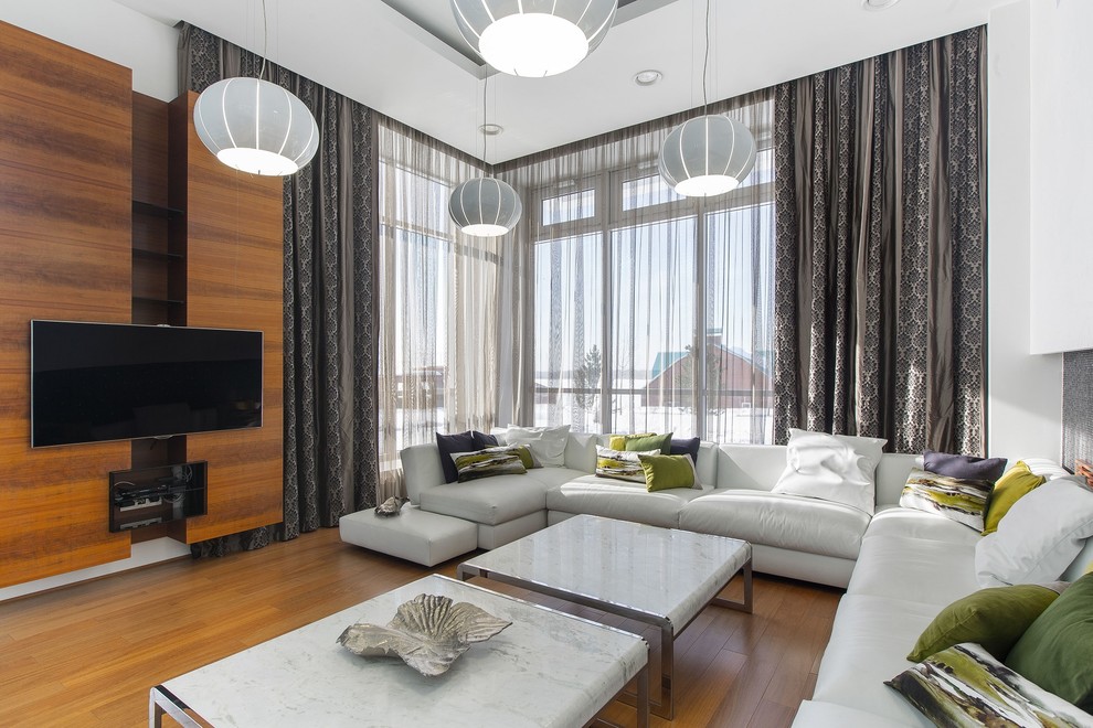 Идея дизайна: гостиная комната в современном стиле с белыми стенами, телевизором на стене и коричневым полом
