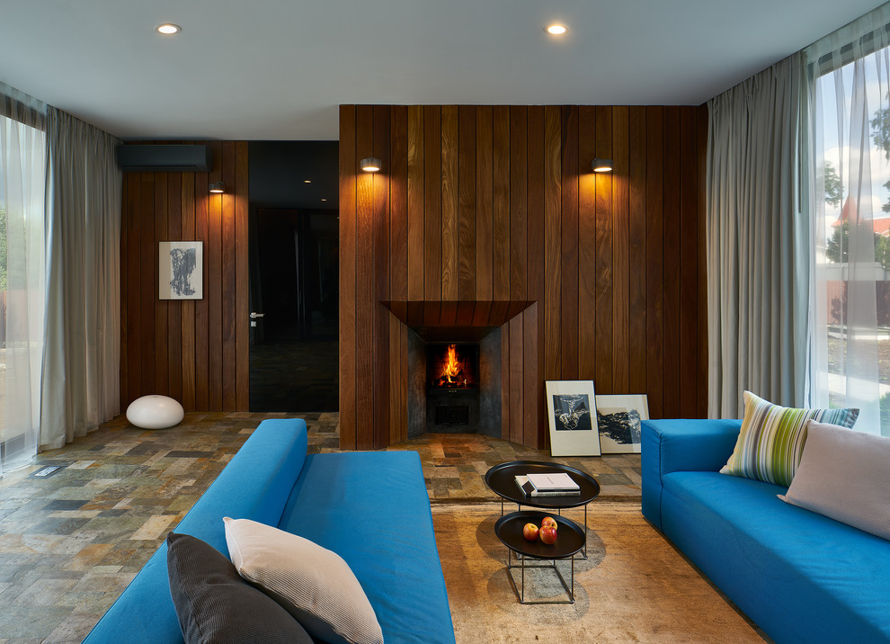 Идея дизайна: гостиная комната среднего размера в современном стиле с коричневыми стенами, стандартным камином и фасадом камина из дерева