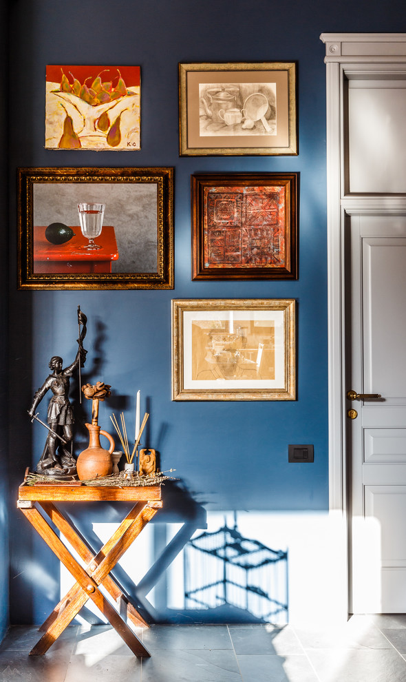 Modelo de salón abierto bohemio grande con paredes azules y suelo de pizarra