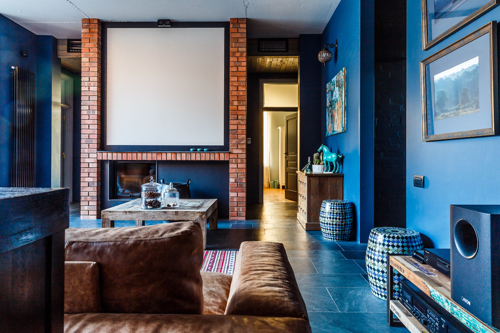 Стильный дизайн: большая открытая гостиная комната в стиле фьюжн с с книжными шкафами и полками, синими стенами, полом из сланца, горизонтальным камином, фасадом камина из кирпича и телевизором на стене - последний тренд