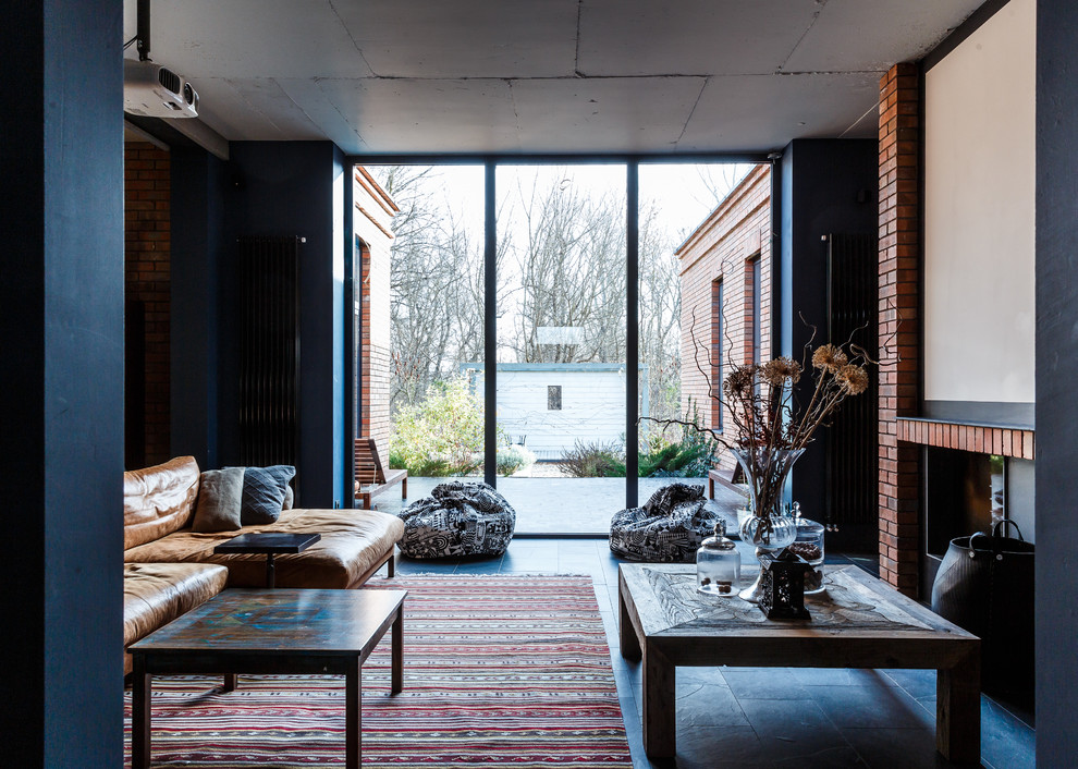 Стильный дизайн: большая открытая гостиная комната в стиле фьюжн с синими стенами и полом из сланца - последний тренд
