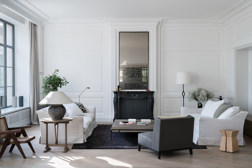 Minimalistisk inredning av ett separat vardagsrum, med ett finrum, vita väggar, ljust trägolv, beiget golv och en standard öppen spis