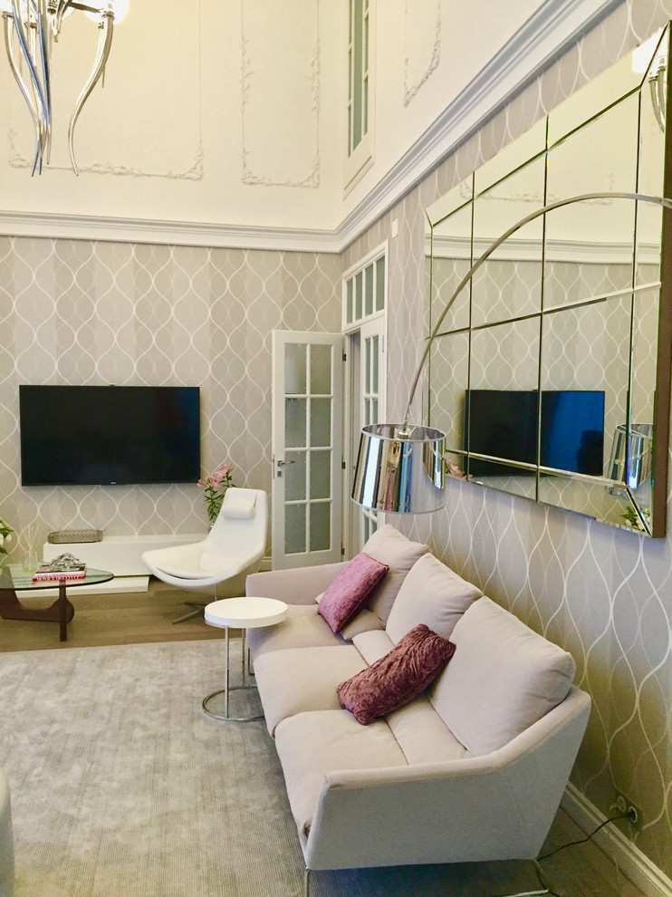 На фото: изолированная гостиная комната среднего размера в стиле неоклассика (современная классика) с музыкальной комнатой, серыми стенами, паркетным полом среднего тона, телевизором на стене и коричневым полом