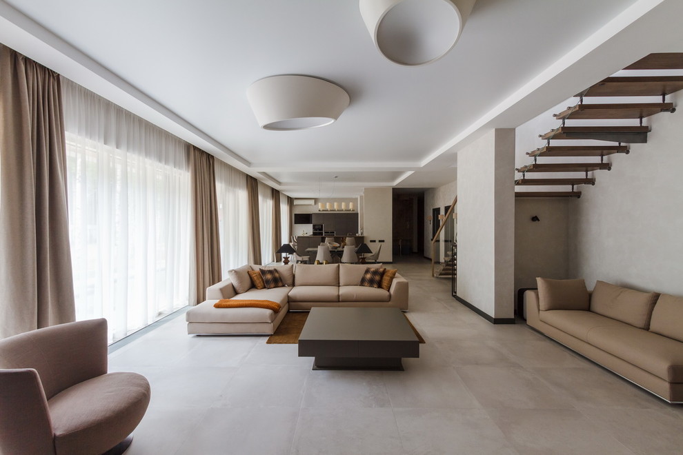 Источник вдохновения для домашнего уюта: большая открытая гостиная комната в современном стиле с серыми стенами и полом из керамогранита
