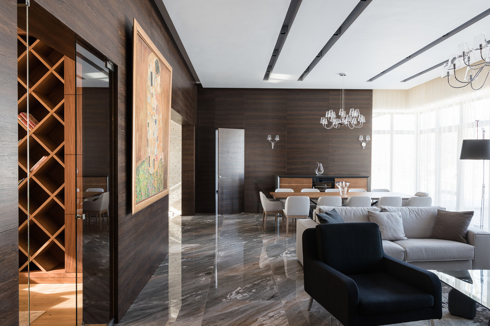 На фото: большая открытая гостиная комната в скандинавском стиле с коричневыми стенами, мраморным полом и серым полом