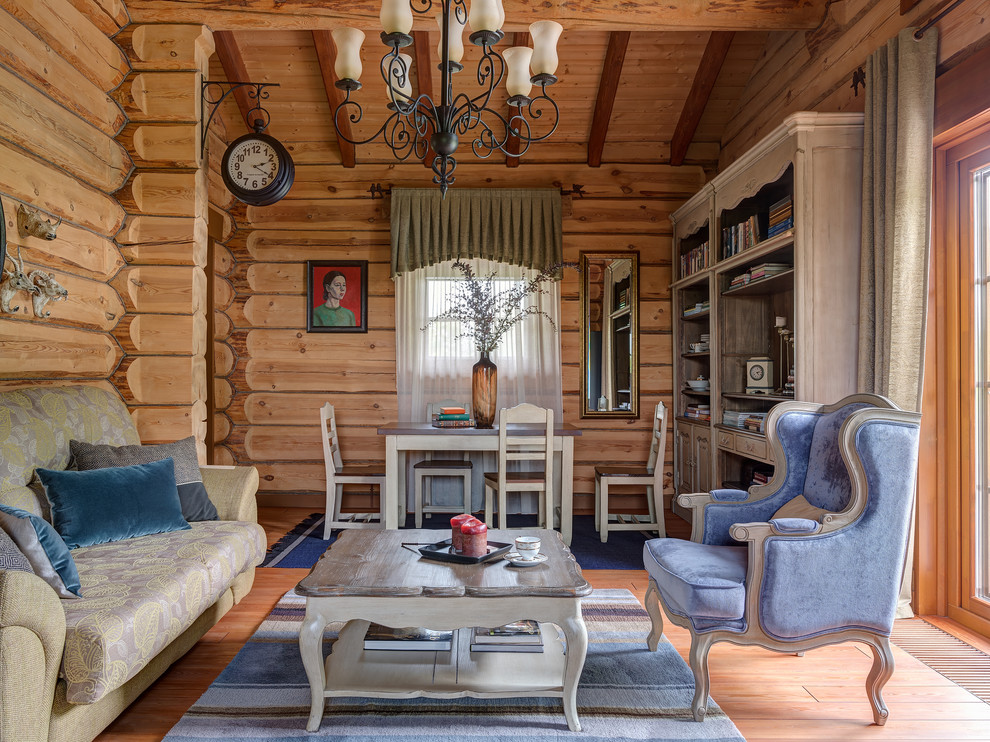 Immagine di un soggiorno stile rurale con libreria, pavimento in legno verniciato e pavimento marrone
