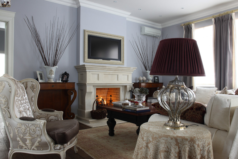На фото: парадная гостиная комната в классическом стиле с стандартным камином и телевизором на стене с