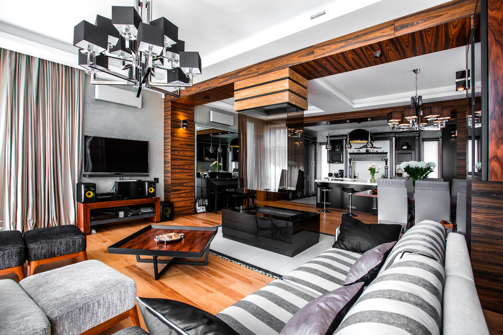 Идея дизайна: открытая гостиная комната в современном стиле с музыкальной комнатой, серыми стенами, паркетным полом среднего тона, двусторонним камином, телевизором на стене и коричневым полом