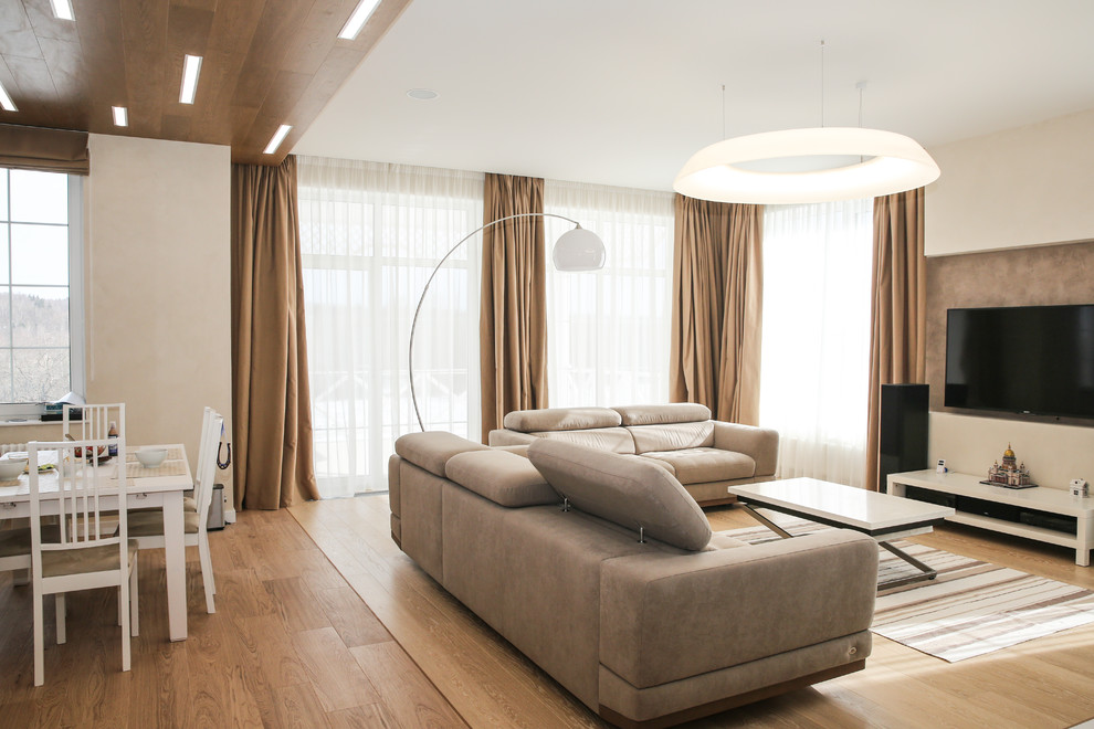 Свежая идея для дизайна: открытая гостиная комната среднего размера в скандинавском стиле с белыми стенами, паркетным полом среднего тона и телевизором на стене - отличное фото интерьера