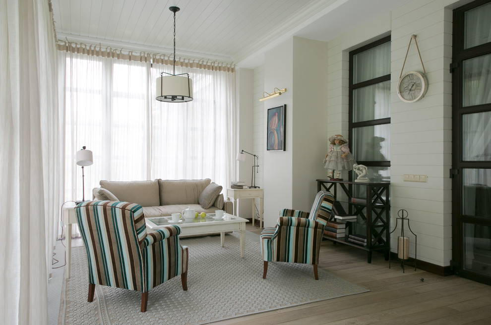 На фото: гостиная комната в стиле неоклассика (современная классика) с тюлем на окнах с