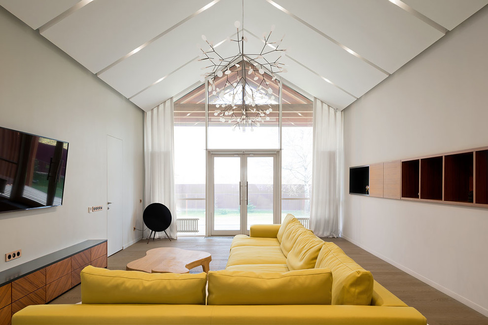 Idee per un grande soggiorno contemporaneo aperto con sala formale, pareti bianche, pavimento in legno massello medio e TV a parete