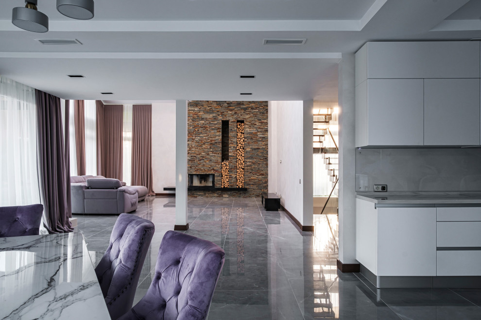 Стильный дизайн: большая открытая гостиная комната в современном стиле с горизонтальным камином, фасадом камина из каменной кладки и серым полом - последний тренд