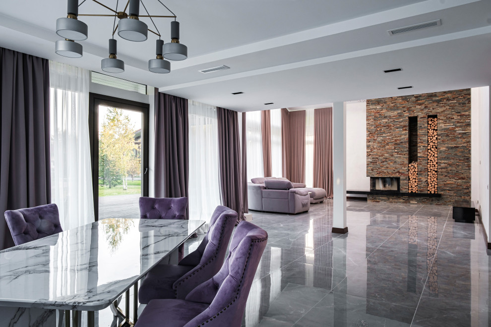 На фото: большая открытая гостиная комната в современном стиле с горизонтальным камином, фасадом камина из каменной кладки и серым полом