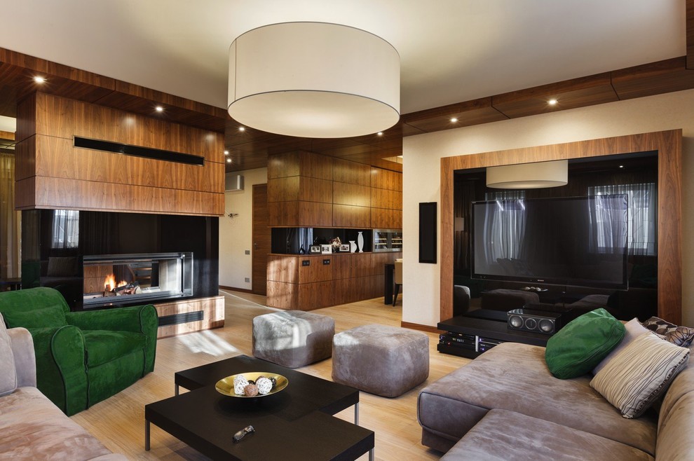Offenes Modernes Wohnzimmer mit beiger Wandfarbe, hellem Holzboden, Tunnelkamin und Multimediawand in Sankt Petersburg