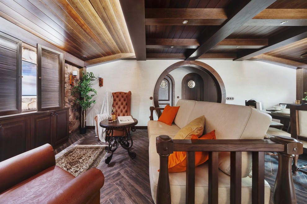 На фото: открытая гостиная комната в стиле фьюжн с бежевыми стенами, полом из керамогранита, скрытым телевизором и коричневым полом