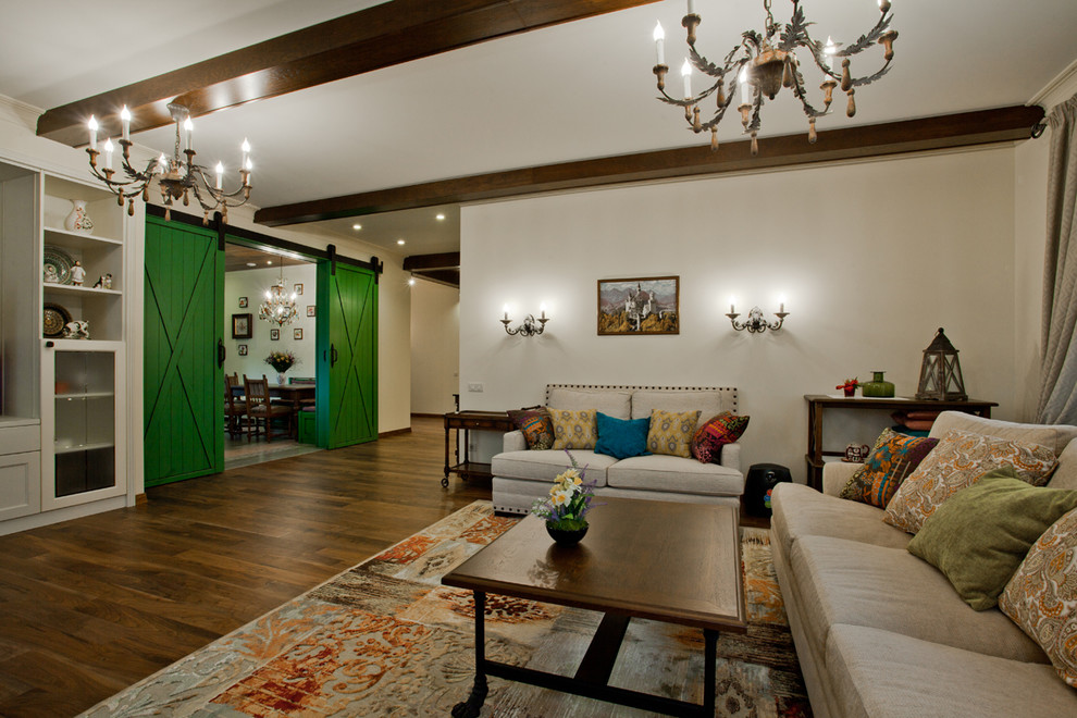 На фото: гостиная комната в стиле кантри с белыми стенами, темным паркетным полом и ковром на полу без камина