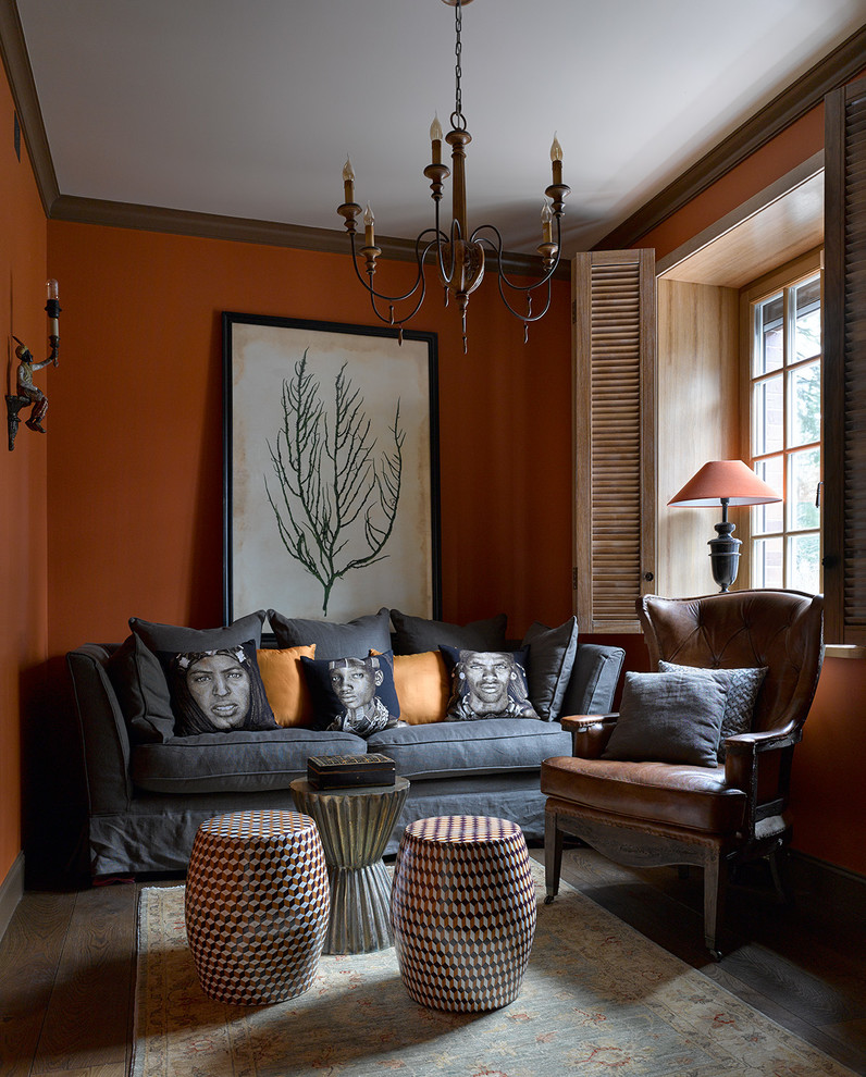 Cette photo montre un salon éclectique avec un mur orange et parquet foncé.