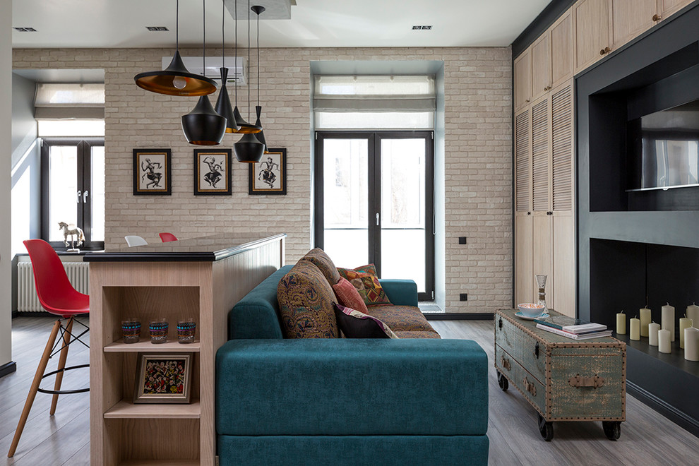 Стильный дизайн: маленькая открытая гостиная комната в стиле фьюжн с белыми стенами, скрытым телевизором, серым полом и кирпичными стенами для на участке и в саду - последний тренд