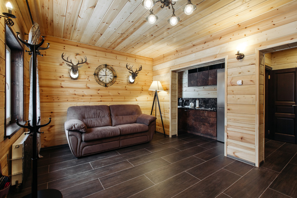 Идея дизайна: маленькая гостиная комната в стиле кантри с полом из керамогранита и коричневым полом для на участке и в саду
