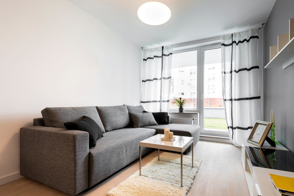 Aménagement d'un salon scandinave de taille moyenne et ouvert avec un mur gris, un sol en bois brun, aucune cheminée et un téléviseur indépendant.