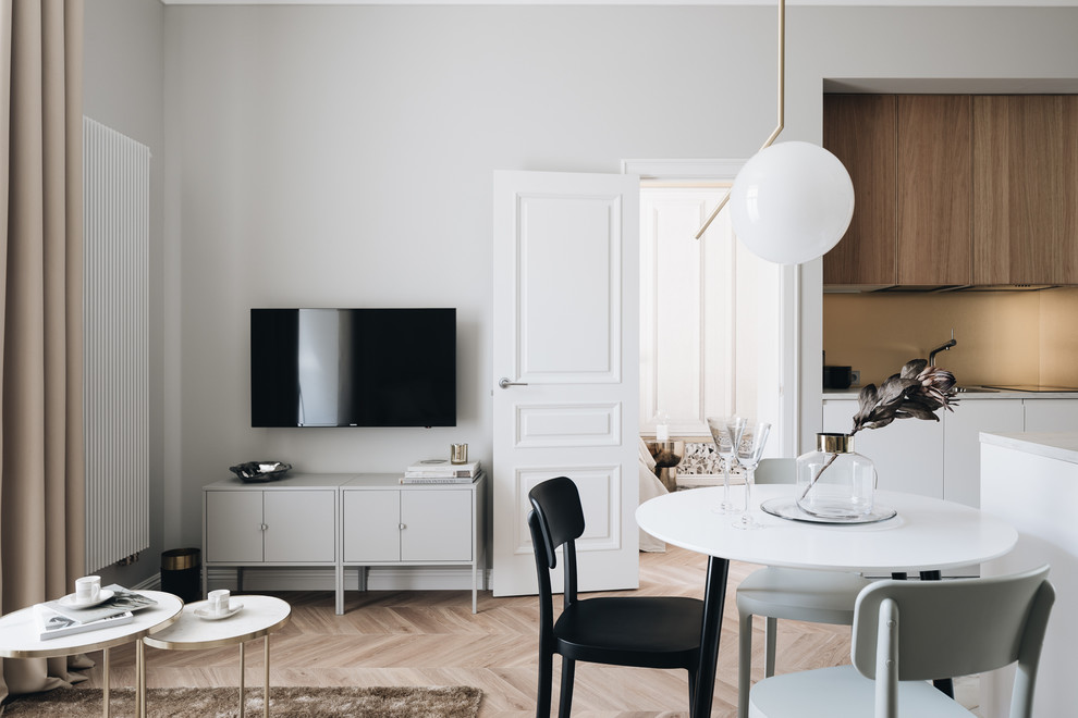 Esempio di un soggiorno chic aperto con sala formale, pareti grigie, parquet chiaro, TV a parete e pavimento beige