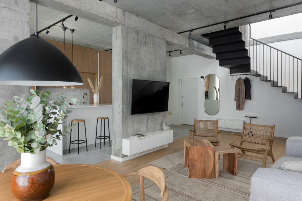 Offenes Modernes Wohnzimmer mit weißer Wandfarbe, braunem Holzboden, TV-Wand und braunem Boden in Sonstige