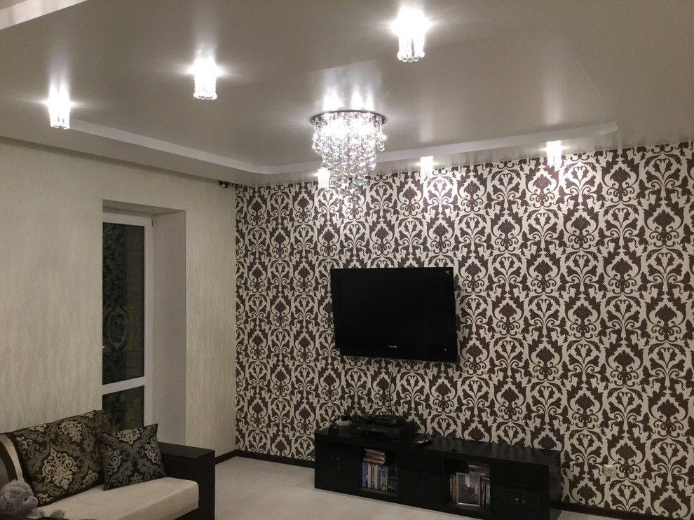 На фото: гостиная комната среднего размера в современном стиле с полом из ламината и телевизором на стене