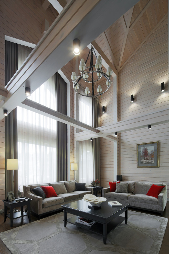 На фото: большая открытая гостиная комната в стиле неоклассика (современная классика) с бежевыми стенами, темным паркетным полом и коричневым полом с