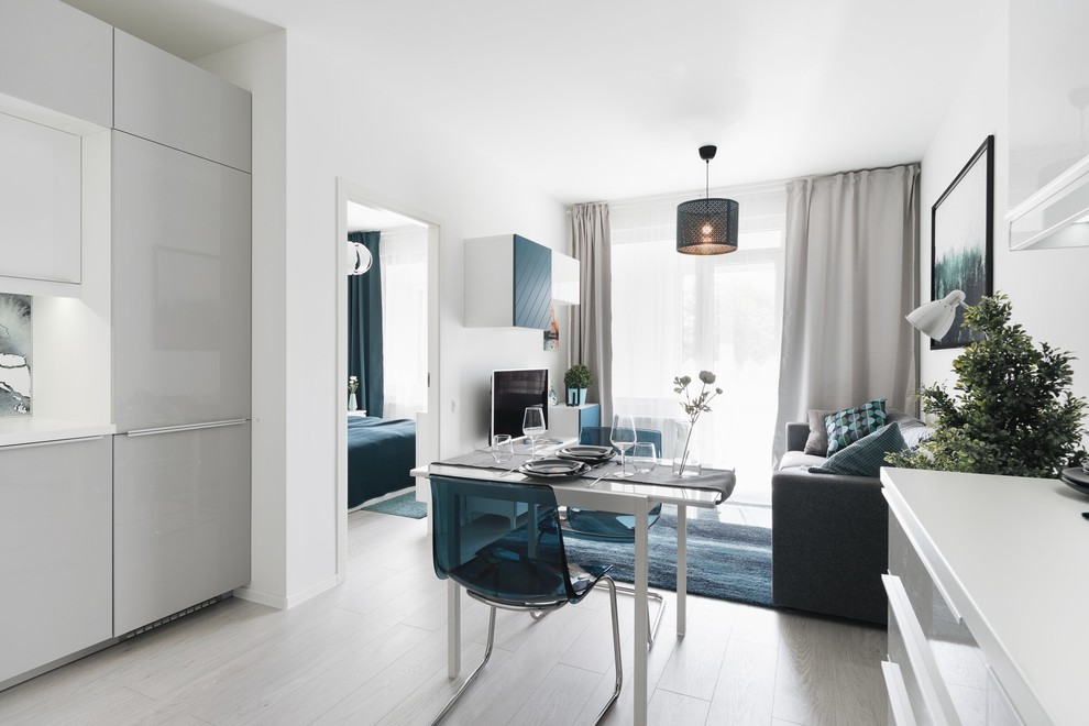 Foto di un soggiorno scandinavo aperto con pareti bianche, pavimento in laminato e pavimento grigio