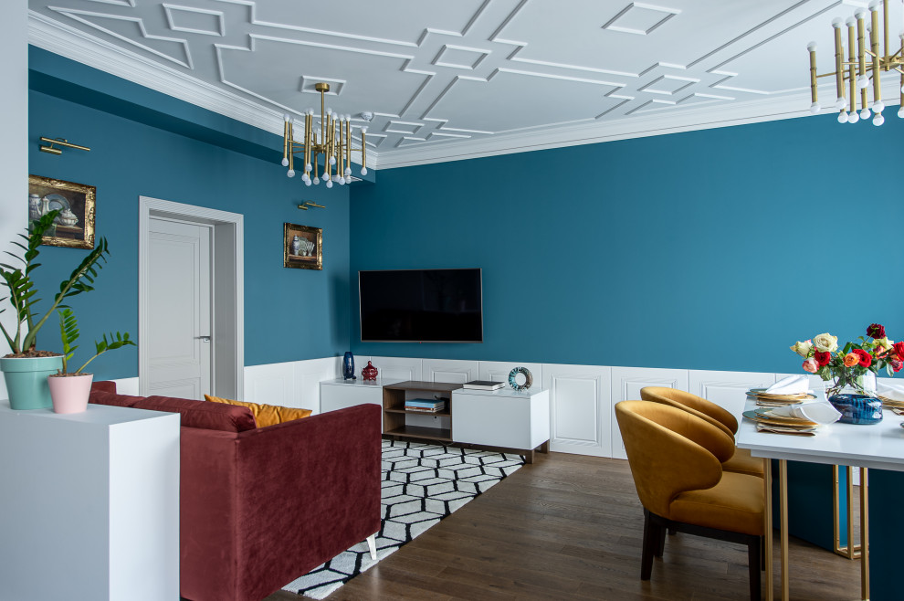 Inredning av ett nordiskt stort vardagsrum, med blå väggar, mellanmörkt trägolv, en väggmonterad TV och brunt golv