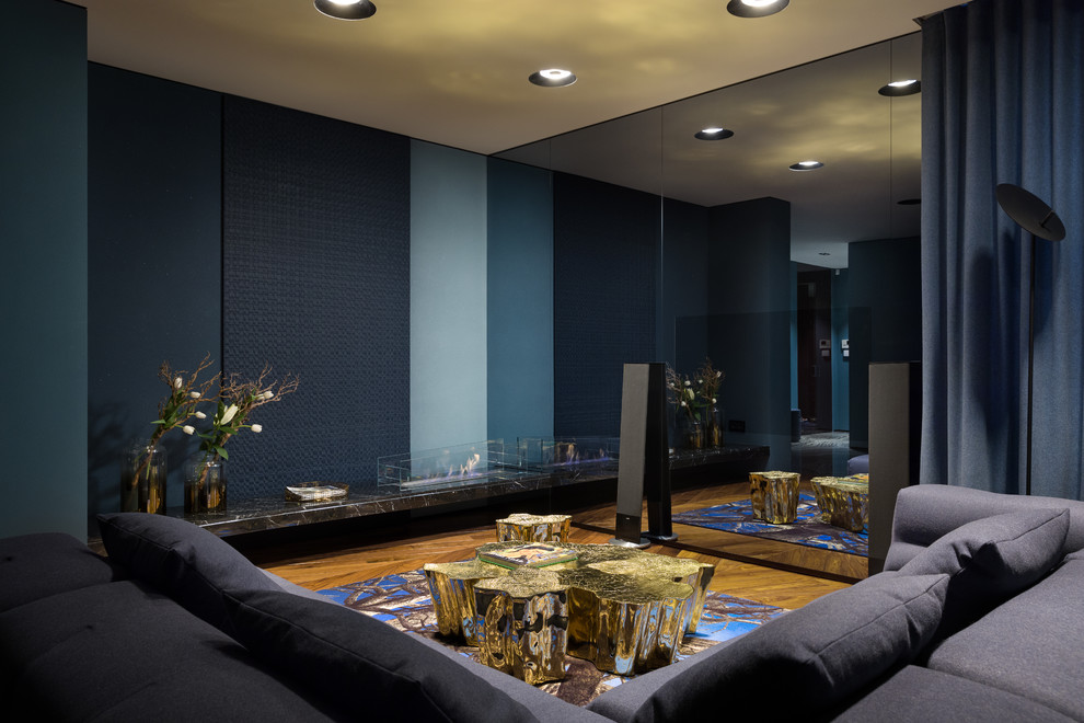 Repräsentatives Modernes Wohnzimmer mit blauer Wandfarbe, braunem Holzboden, Eckkamin und braunem Boden in Sonstige