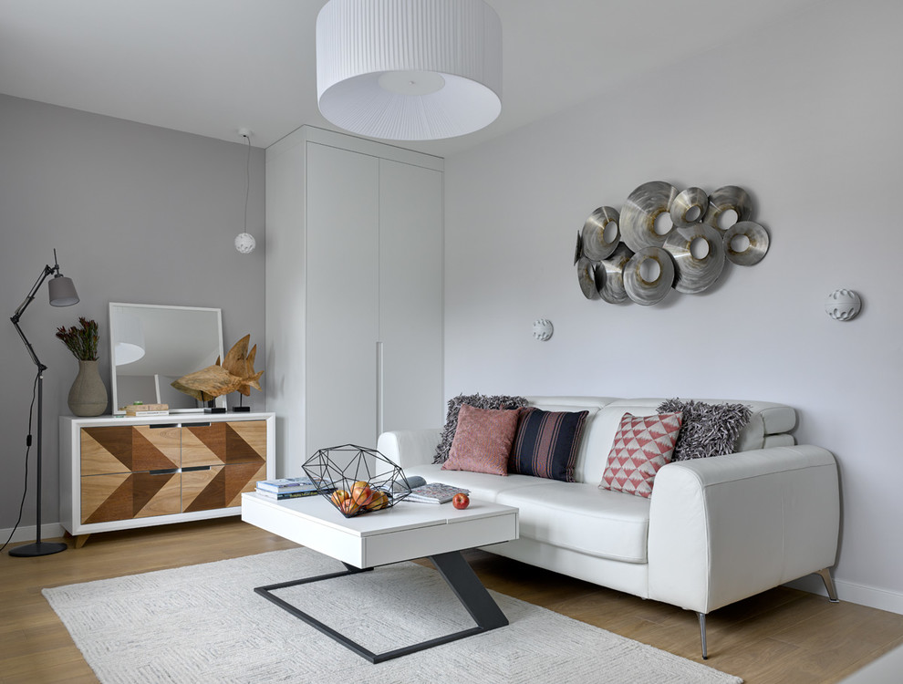 Идея дизайна: изолированная гостиная комната в современном стиле с серыми стенами и светлым паркетным полом
