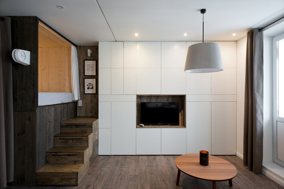 Пример оригинального дизайна: маленькая парадная, открытая, объединенная гостиная комната в современном стиле с белыми стенами, полом из ламината и отдельно стоящим телевизором без камина для на участке и в саду