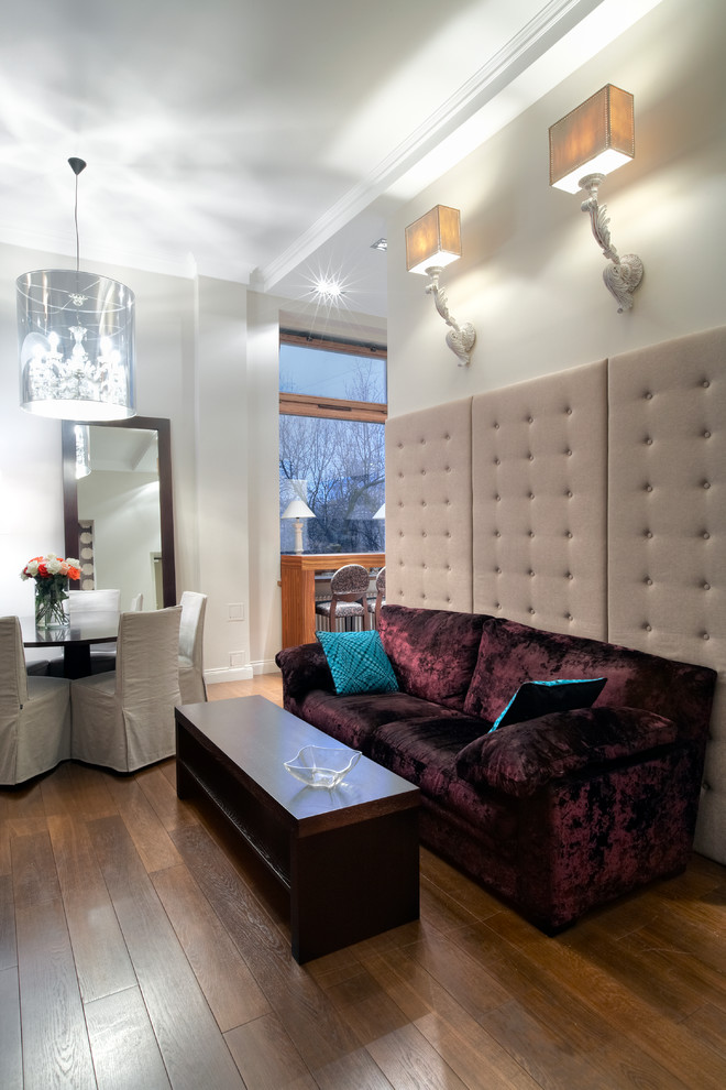 На фото: маленькая открытая гостиная комната в современном стиле с бежевыми стенами, деревянным полом и бордовым диваном для на участке и в саду