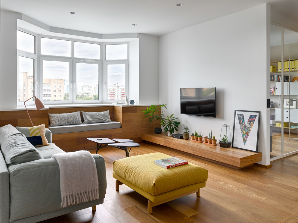Inspiration for a contemporary formal open plan living room in Moscow with white walls, painted wood flooring, a wall mounted tv and brown floors.
