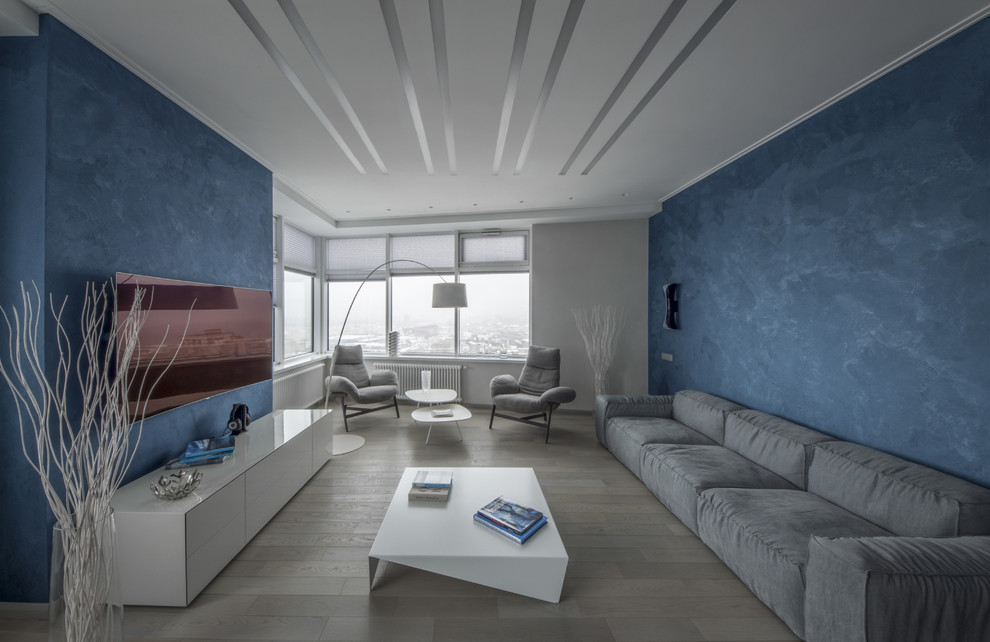Источник вдохновения для домашнего уюта: парадная, открытая гостиная комната среднего размера в современном стиле с синими стенами, светлым паркетным полом, телевизором на стене и бежевым полом без камина