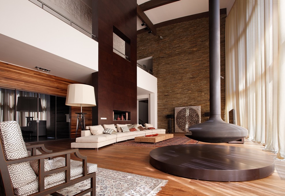 Photo of an expansive contemporary formal open plan living room in Moscow with brown walls and a hanging fireplace.