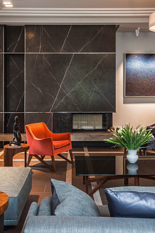 Идея дизайна: гостиная комната в современном стиле с стандартным камином и фасадом камина из камня
