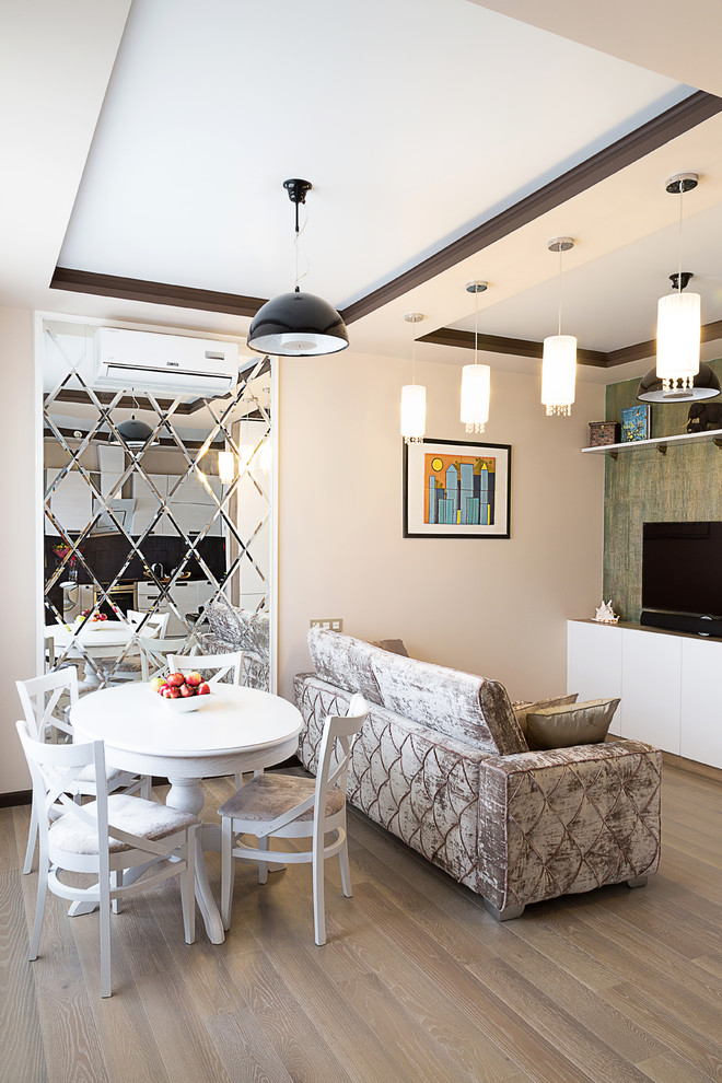 На фото: парадная, открытая гостиная комната в современном стиле с бежевыми стенами, светлым паркетным полом и отдельно стоящим телевизором с