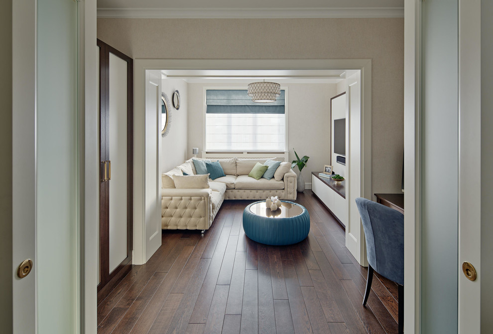 Imagen de salón cerrado actual con paredes beige, suelo de madera oscura y televisor colgado en la pared