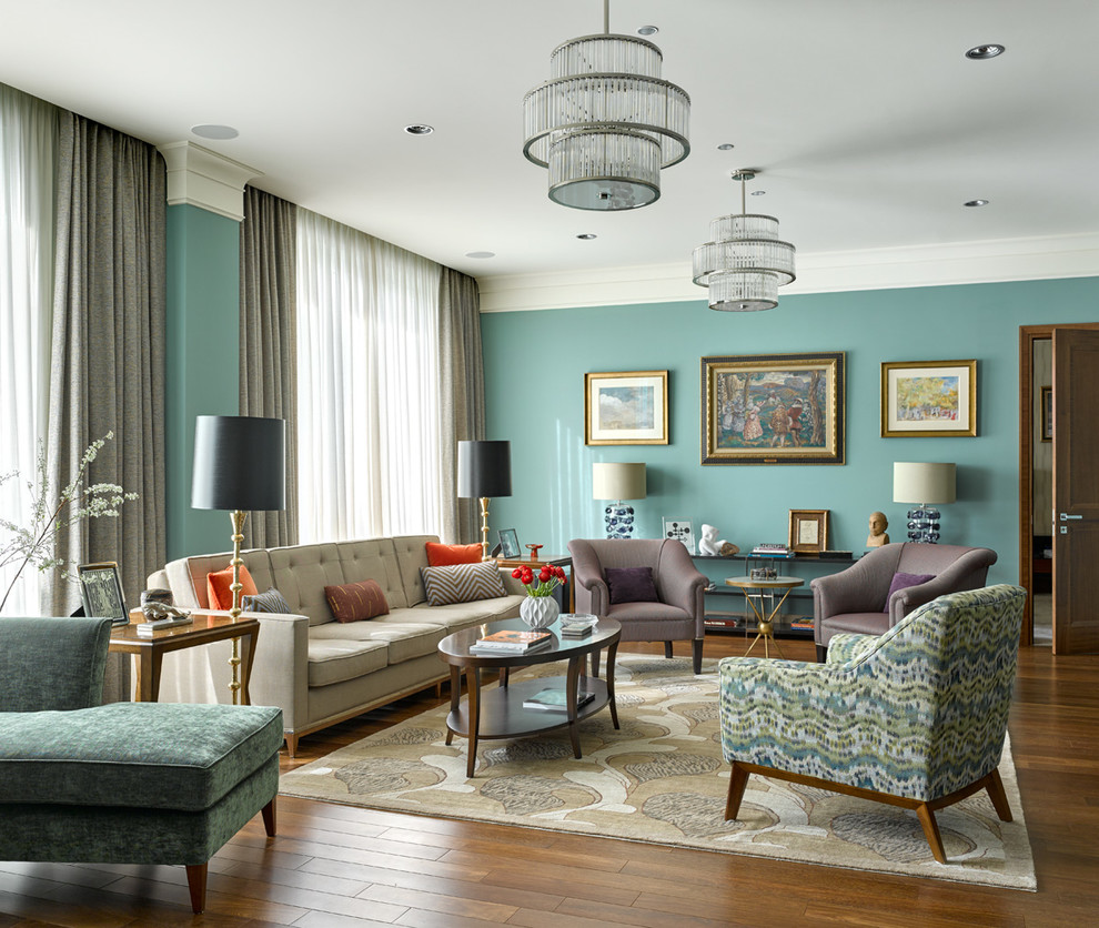 Idée de décoration pour un grand salon bohème avec un mur bleu, une salle de réception et un sol en bois brun.