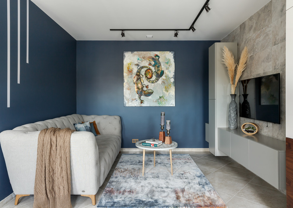Свежая идея для дизайна: гостиная комната в современном стиле с синими стенами, телевизором на стене, бежевым полом и акцентной стеной без камина - отличное фото интерьера
