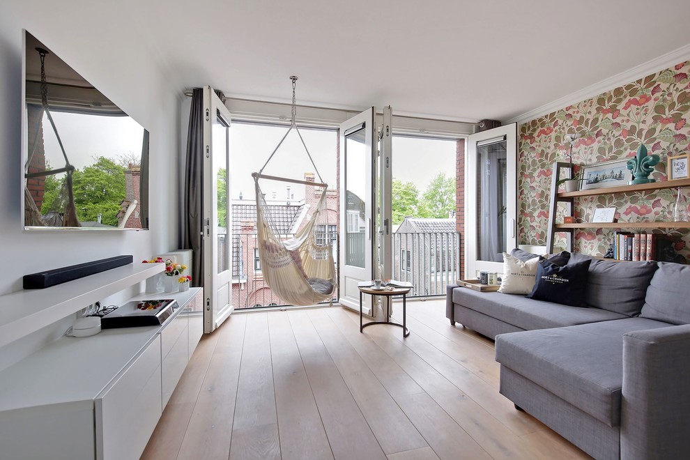 Immagine di un soggiorno bohémian con pareti bianche, pavimento in legno massello medio, TV a parete e pavimento beige