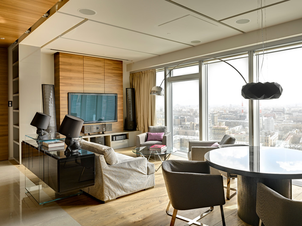Immagine di un soggiorno minimal con pareti bianche, parquet chiaro, TV a parete e pavimento beige