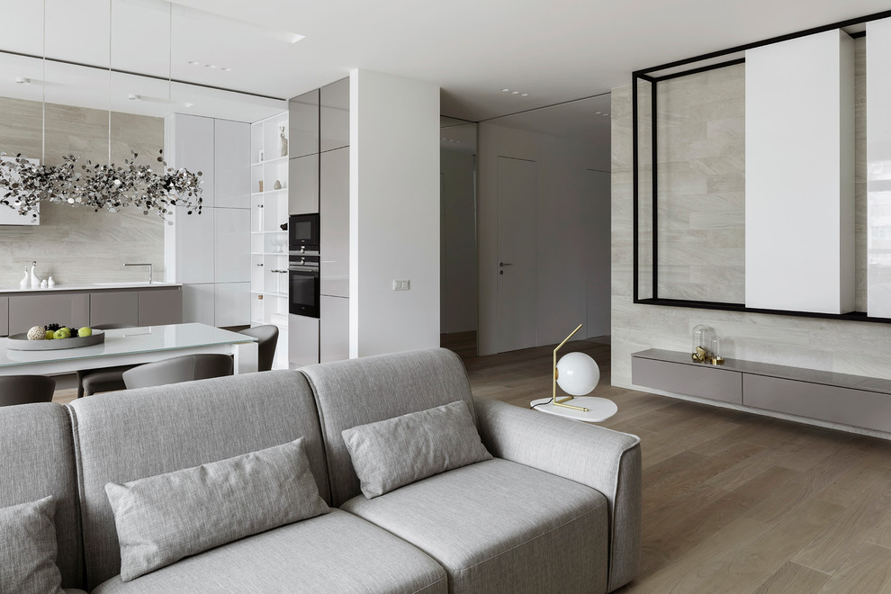 Réalisation d'un salon design ouvert avec une salle de réception, un mur gris et parquet clair.