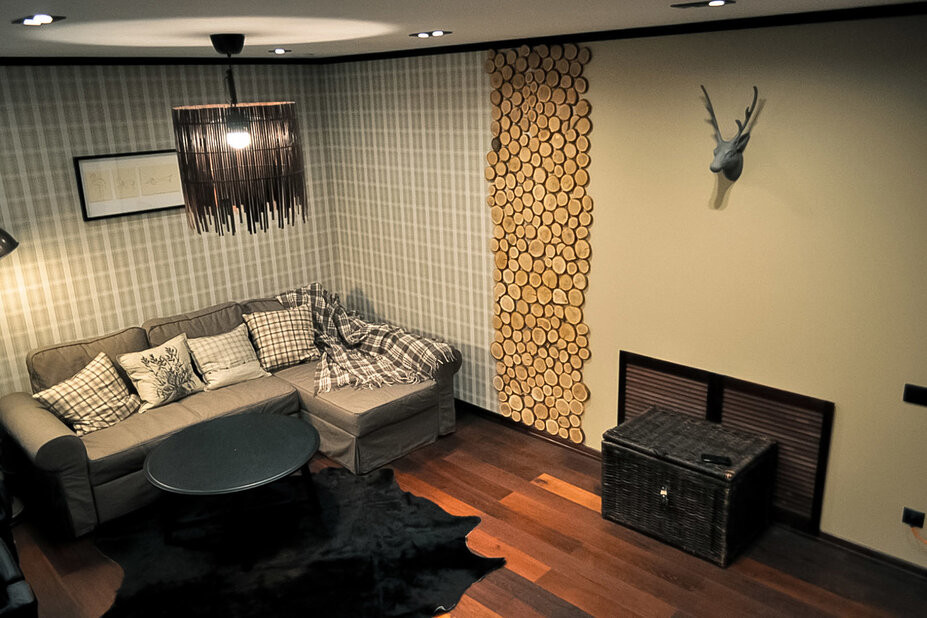 Diseño de salón con barra de bar escandinavo de tamaño medio sin chimenea con suelo de madera oscura, pared multimedia, suelo marrón y paredes grises