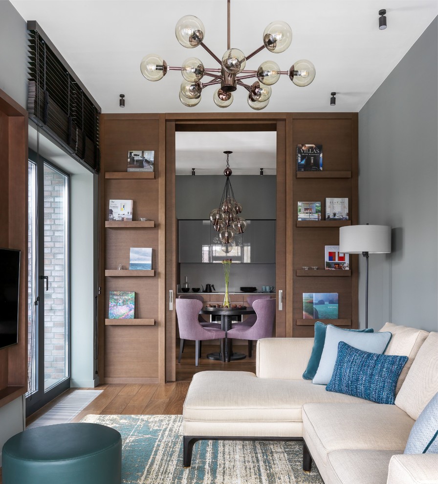 На фото: парадная, изолированная, объединенная гостиная комната среднего размера в современном стиле с серыми стенами, паркетным полом среднего тона, телевизором на стене и коричневым полом без камина