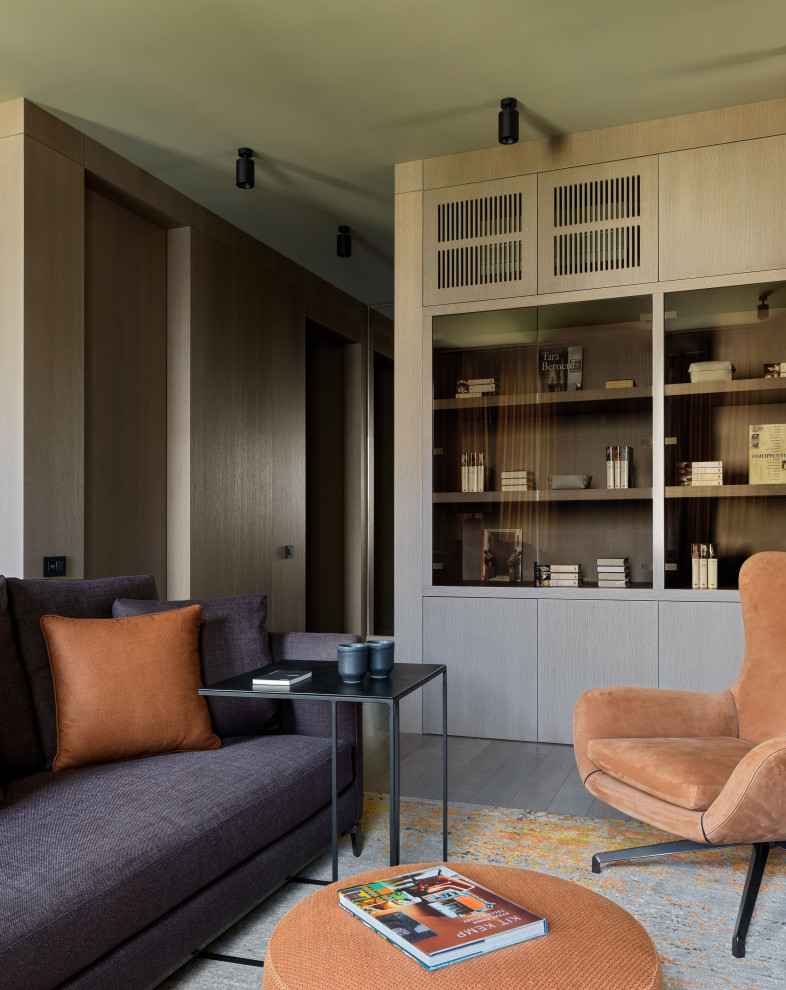 Пример оригинального дизайна: большая открытая гостиная комната в современном стиле с с книжными шкафами и полками, коричневыми стенами, паркетным полом среднего тона, телевизором на стене, коричневым полом и деревянными стенами