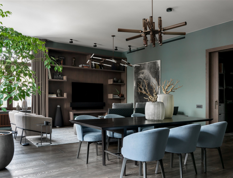 Свежая идея для дизайна: большая гостиная комната в современном стиле с зелеными стенами, паркетным полом среднего тона, телевизором на стене и коричневым полом - отличное фото интерьера